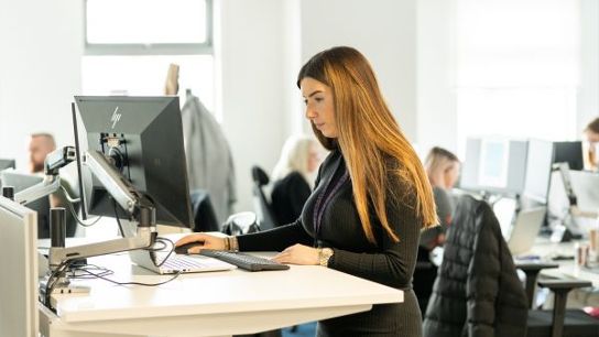 Person working at a desk in a busy office environment.