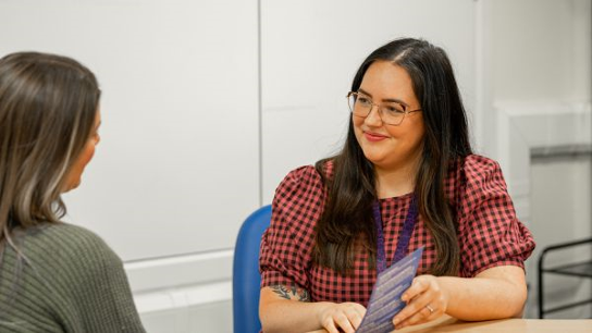 Two people seated at a table, engaged in conversation.