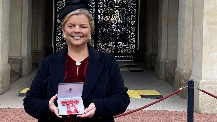 Jen Hardy MBE holding her MBE in a presentation box