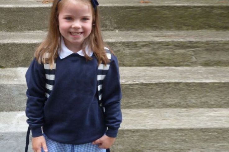 Primary school girl standing in front a set of outdoor steps