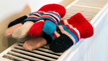 A pair of colourful knitted gloves on a radiator