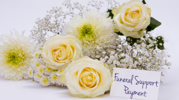 Bouquet of cream and white flowers with a card reading “Funeral Support Payment.