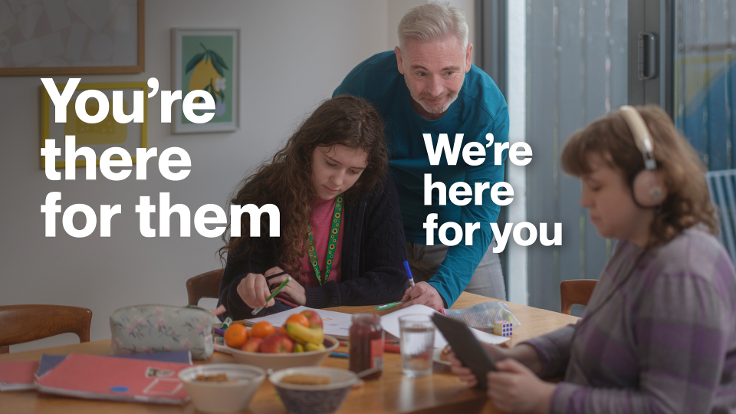 A carer is helping two young people with homework, one is writing and one is using a tablet. Text reads: You're there for them. We're here for you.