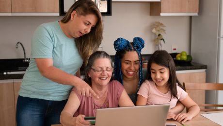 A family is looking at a laptop