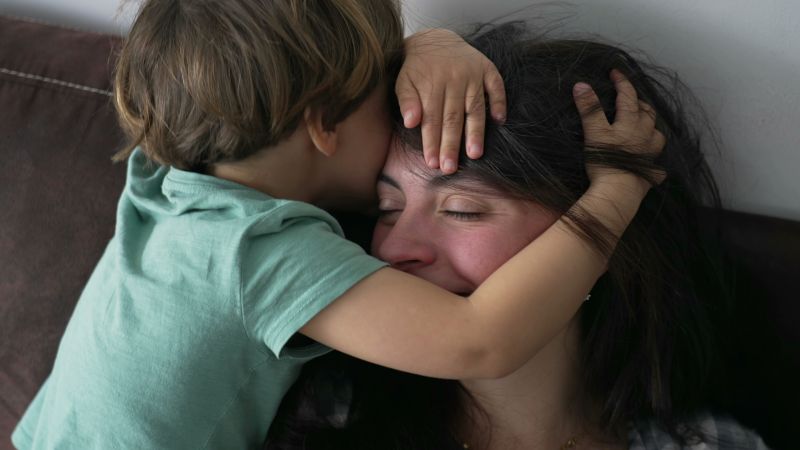 Young boy cuddles his mother