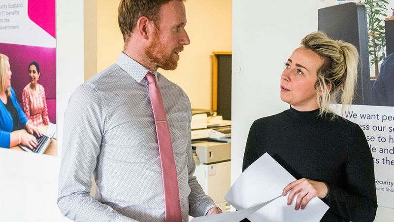 Two colleagues standing talking to each other.