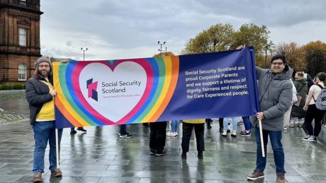 Social Security Scotland colleagues are in Glasgow holding a banner that says 'Social Security Scotland are proud Corporate Parents and we support a lifetime of dignity, fairness and respect for Care Experienced People.'