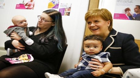 First Minister, Nicola Sturgeon sitting with a baby on her knee