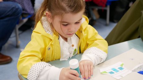 Young girl sitting doing crafts at a table