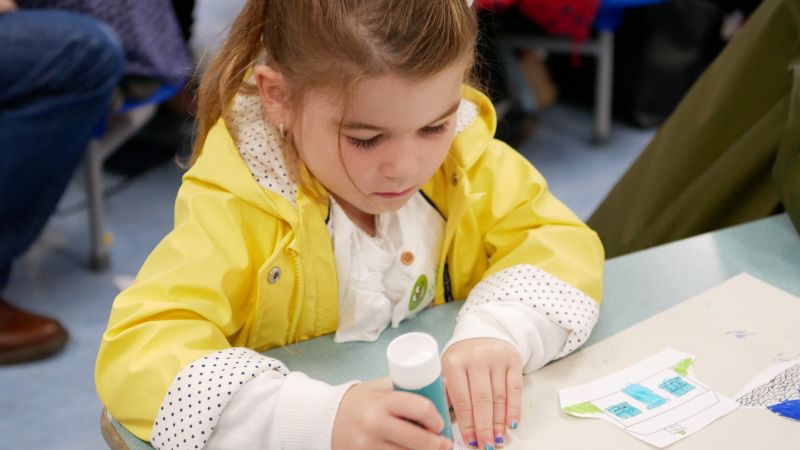 Young girl sitting doing crafts at a table