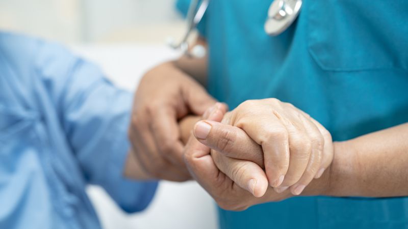 Nurse holding a patient's hand