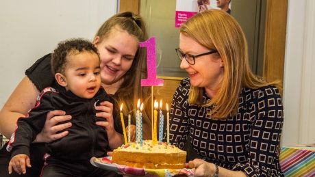 Cabinet Secretary, Shirley Anne Somerville holds a cake as a young child prepares to blow out the candles