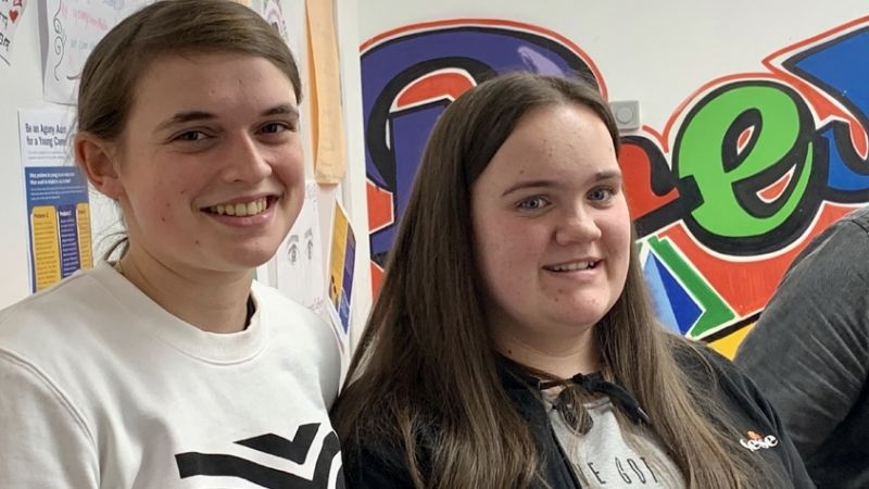 Two young carers smiling at the camera