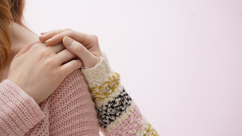 Woman with a reassuring hand on her shoulder