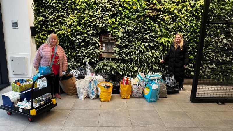 Colleagues standing with donations