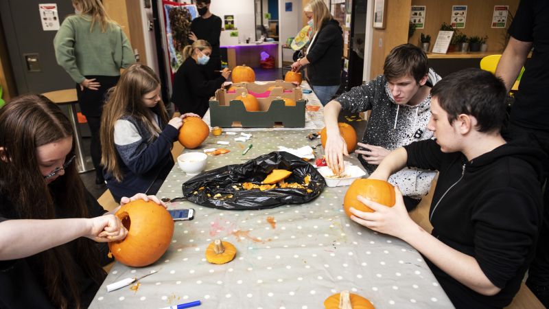 A group of people are carving pumpkins