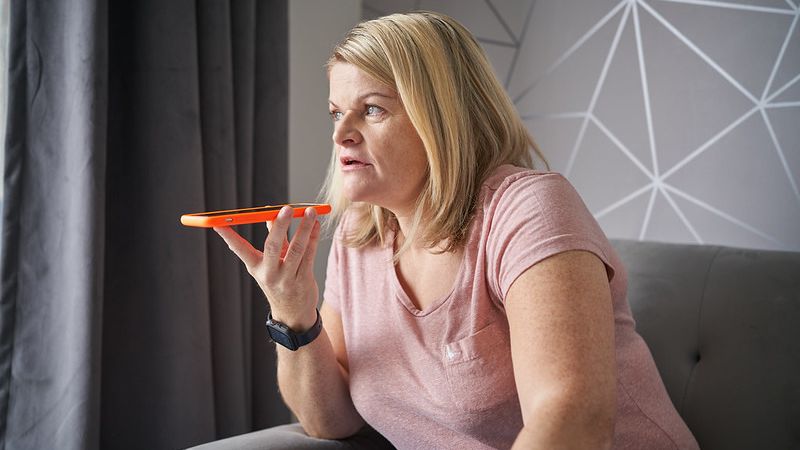 Female sitting down holding her mobile phone