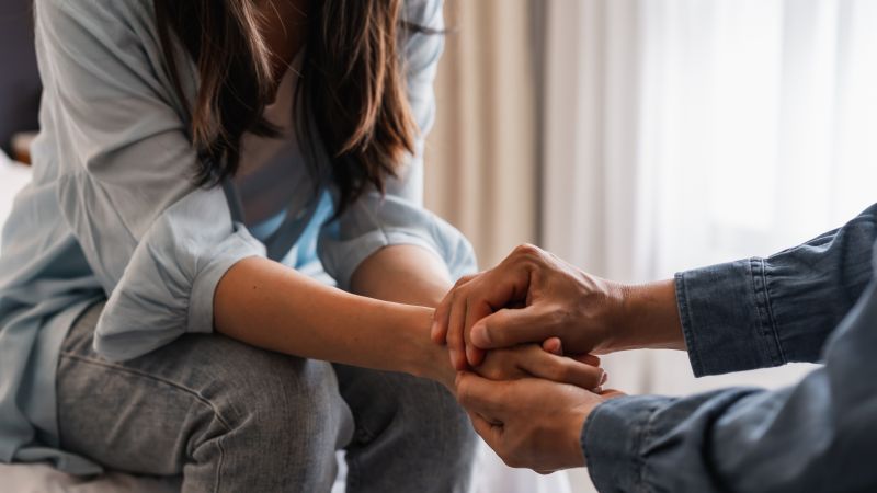 Two people holding each others' hands